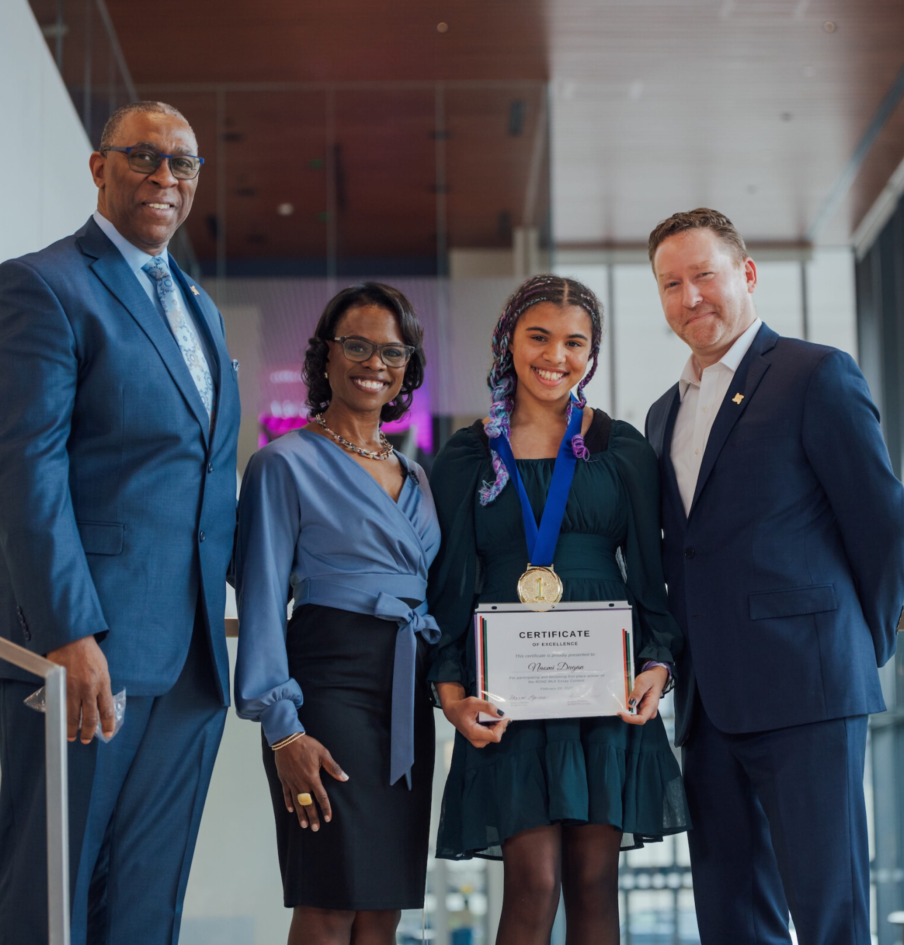 Trois adultes posant et souriant avec l’un des gagnants du concours de rédaction pour les jeunes de Cencora en l’honneur de Martin Luther King Jr. 