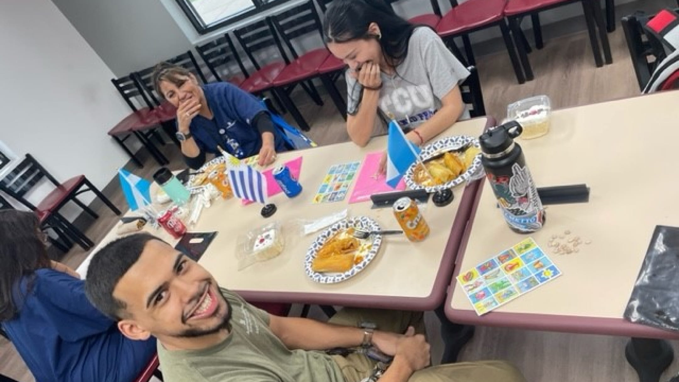 Four workers having a meal and sharing a laugh around a table as they celebrate Hispanic Heritage Month.
