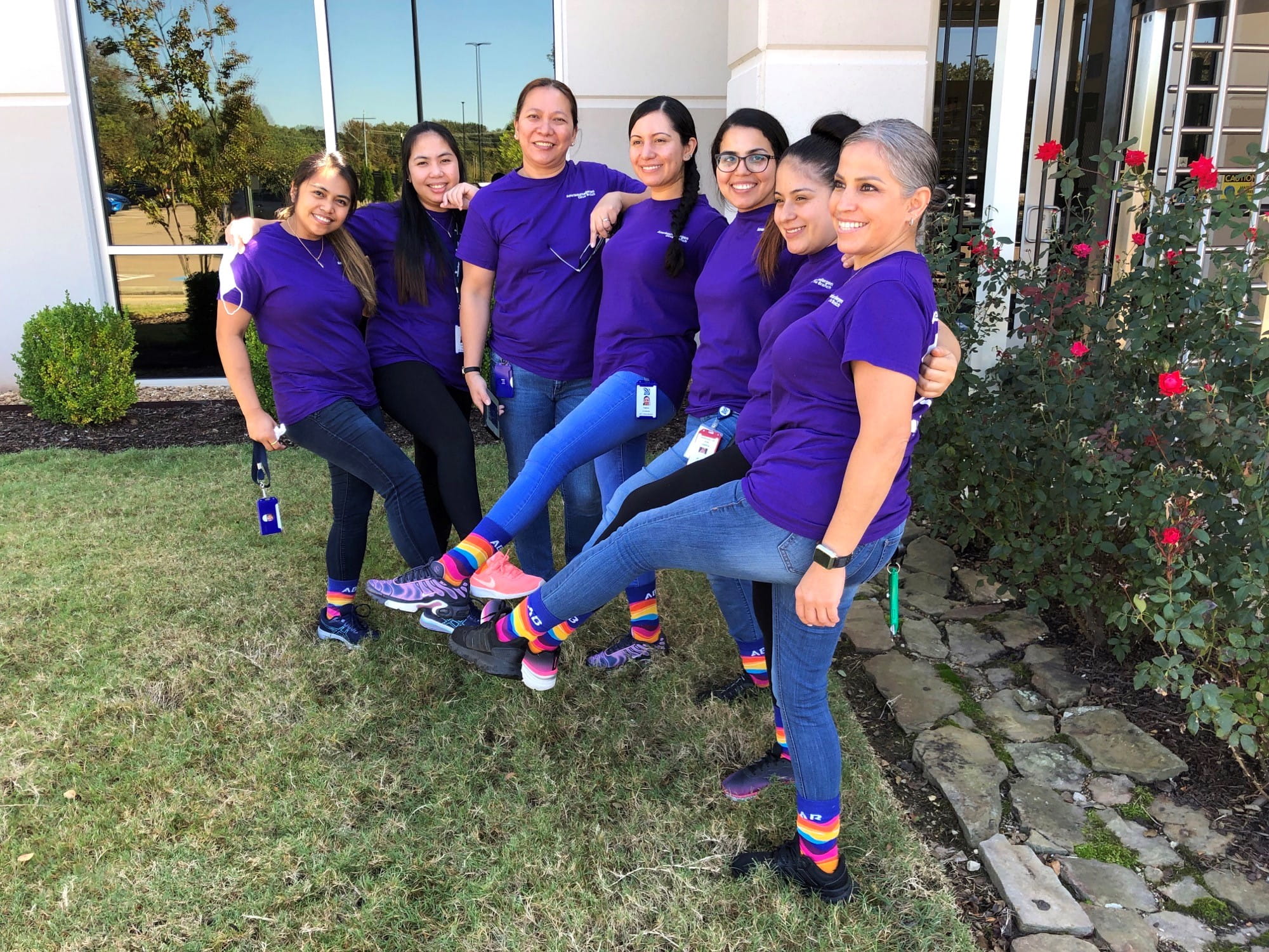 Un groupe de sept femmes exhibent leurs chaussettes sur le thème de la fierté arc-en-ciel en soutien à la communauté LGBTQ+.