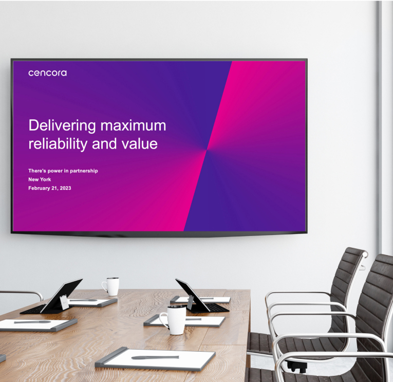 A large screen displays the opening slide of a presentation in a meeting room.
