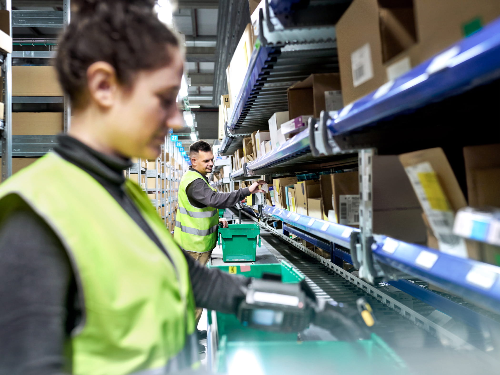 Two Cencora team members wearing yellow safety vests in our distribution center, working to make healthcare products available and affordable.