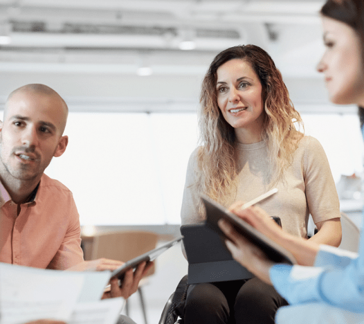 Un groupe de trois employés de bureau participe à une réunion sur le lieu de travail.