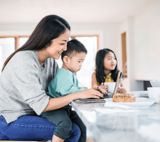 Une famille asiatique passe du temps en famille autour de l’îlot de cuisine. 